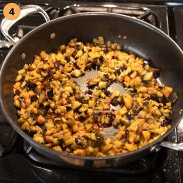 cooking diced eggplants, peppers, onions and garlic in a pan.