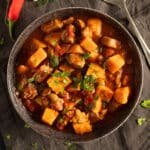 pork and sweet potato stew sprinkled with parsley in a serving bowl.