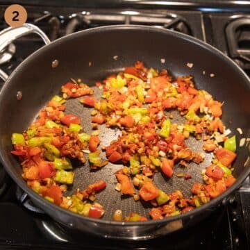 sauteing diced onions, peppers and garlic to make stew in a pot.