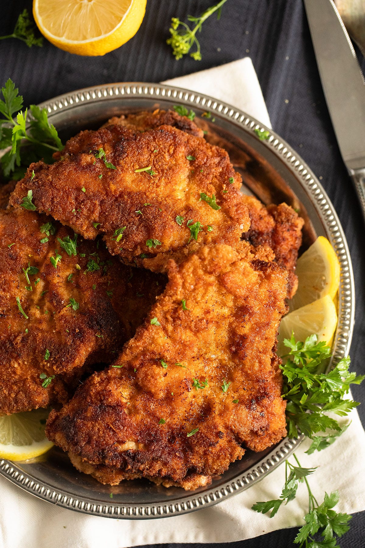 crispy turkey schnitzels and lemon pieces on a plate.