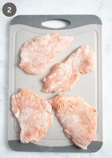 floured turkey breast cutlets on a cutting board.