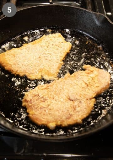 cooking turkey schnitzels in a skillet in lots of oil.