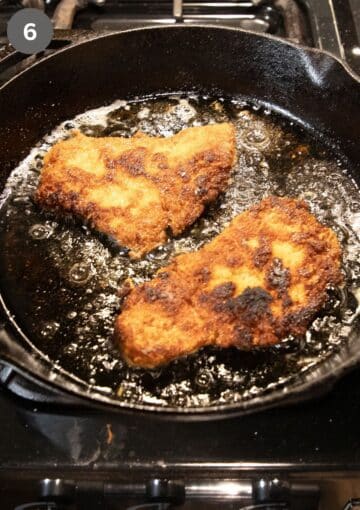 frying turkey schnitzel in a cast iron skillet.