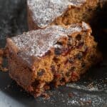 a slice of fruitcake with raisins, cranberries and other dried fruit.