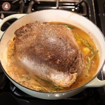 piece of deer meat in bubbling liquid in a large pot.