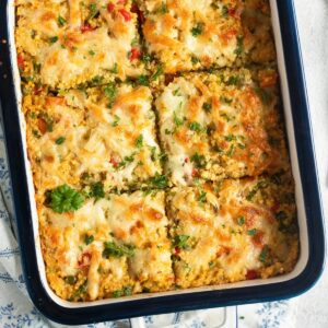 millet bake cut into squares and sprinkled with parsley in a casserole dish.