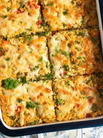 millet bake cut into squares and sprinkled with parsley in a casserole dish.