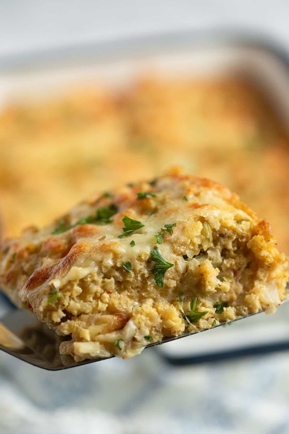 a slice of baked millet with vegetables on a spatula.