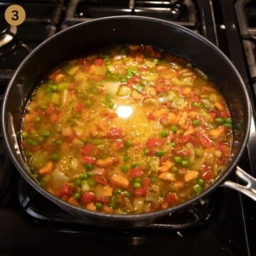 adding broth to millet and vegetables in a saucepan.