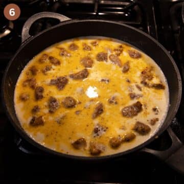 chicken pieces in cream and stock sauce in a large pan.