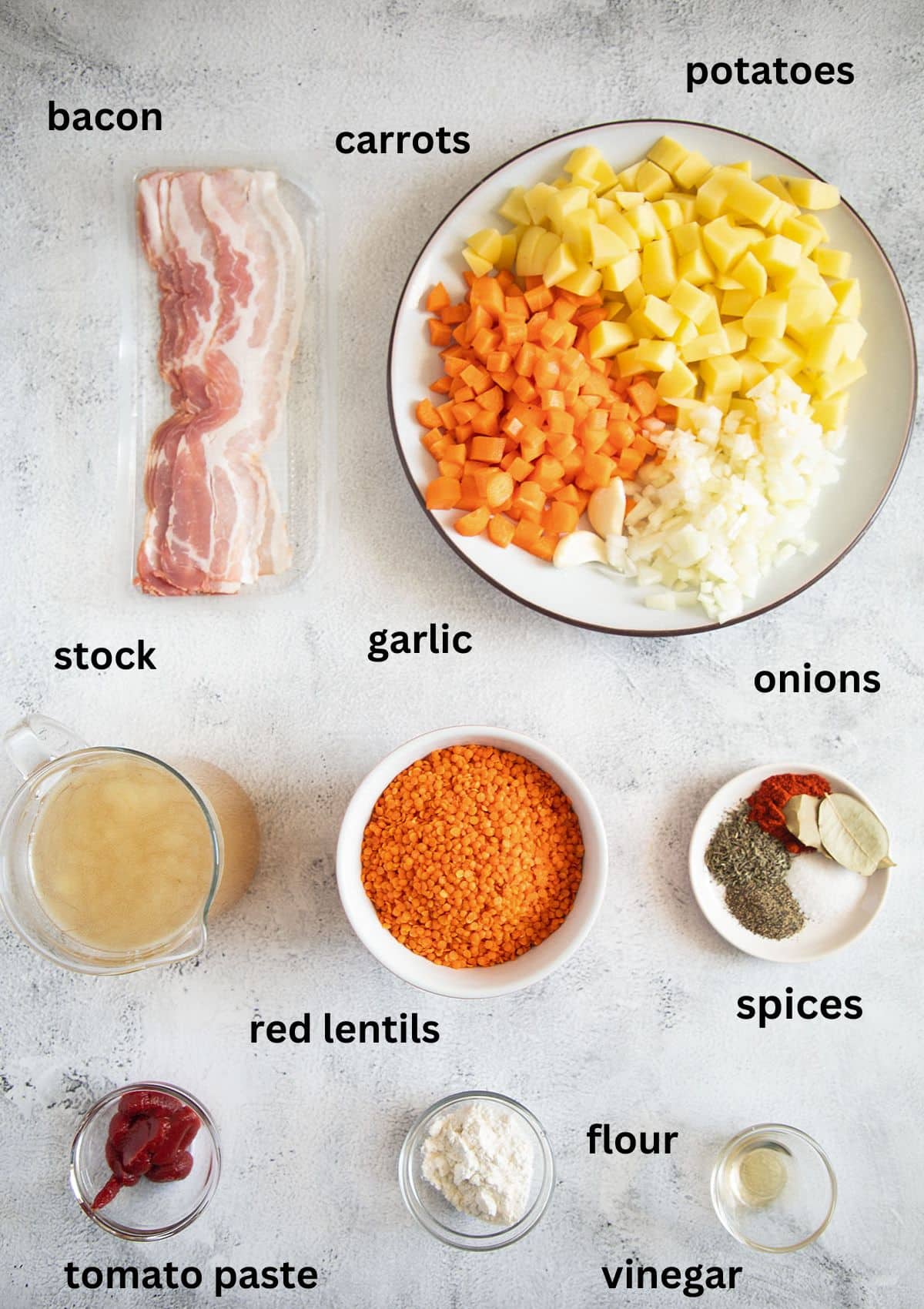 labeled ingredients for making soup with red lentil, carrots, potatoes and bacon.