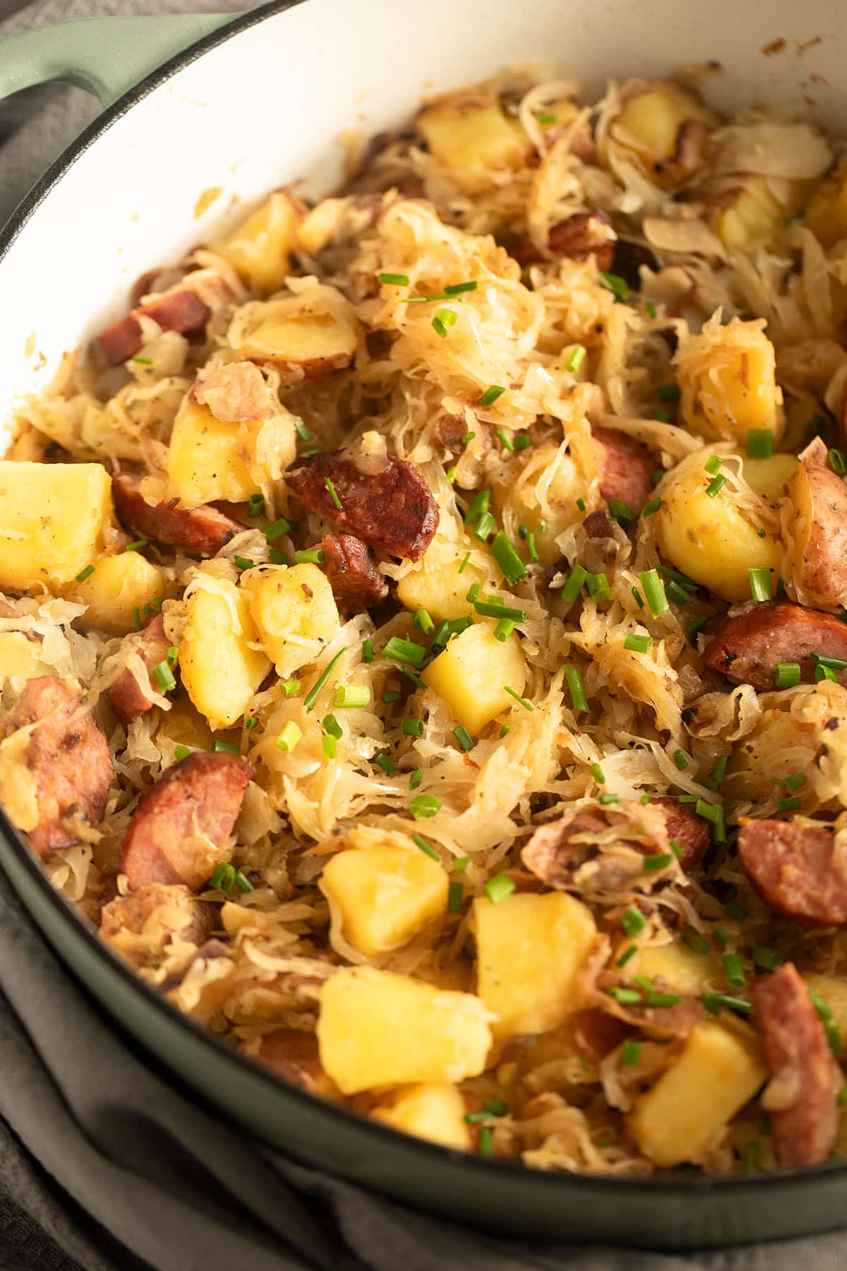 sauerkraut, kielbasa and potatoes in a pot.