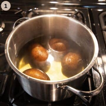 cooking four potatoes in a pot of water.