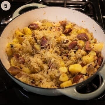 sauerkraut with sausages and potatoes in a large dutch oven.