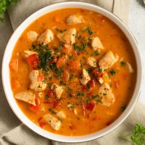 paprika chicken soup sprinkled with parsley in a bowl.