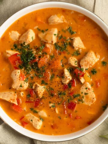 paprika chicken soup sprinkled with parsley in a bowl.