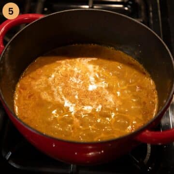 bubbling chicken soup with paprika in a dutch oven.