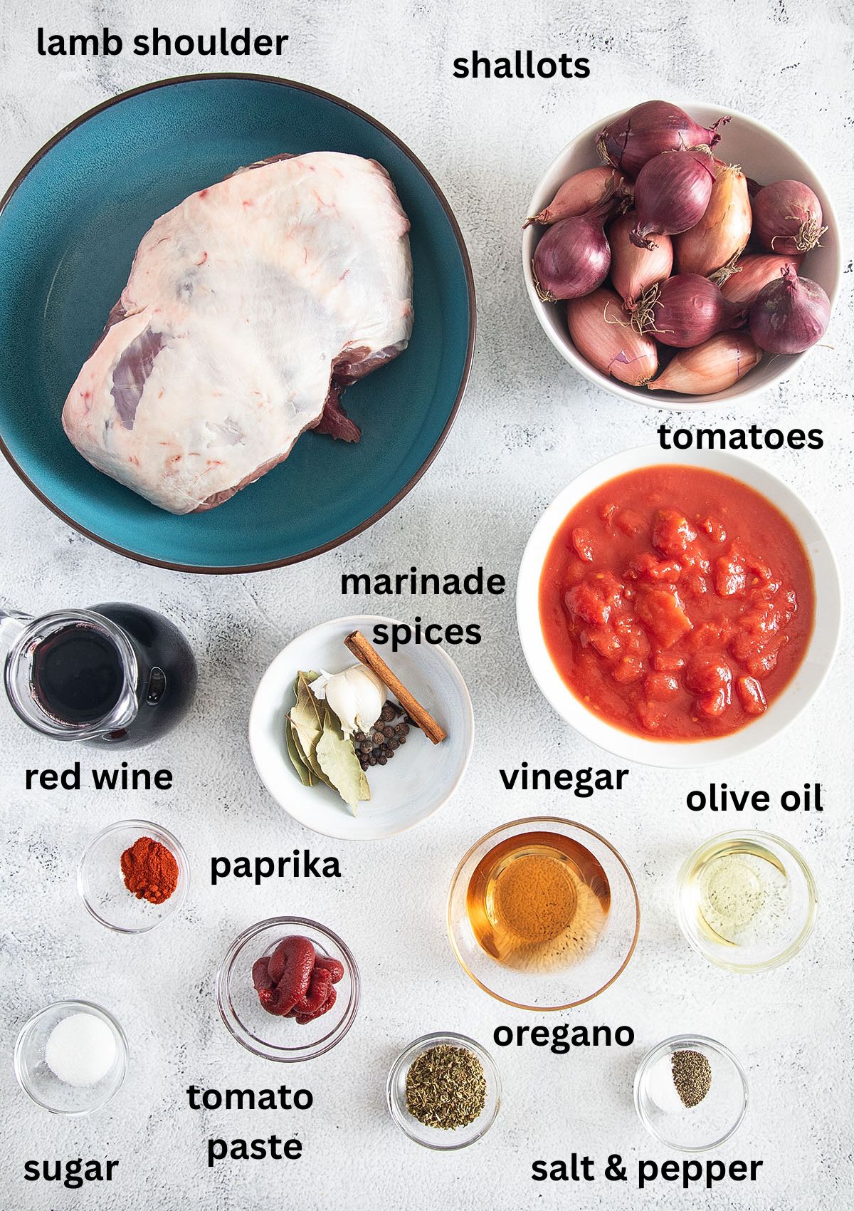 labeled ingredients for making lamb stifado with shallots, tomatoes, red wine, and spices.