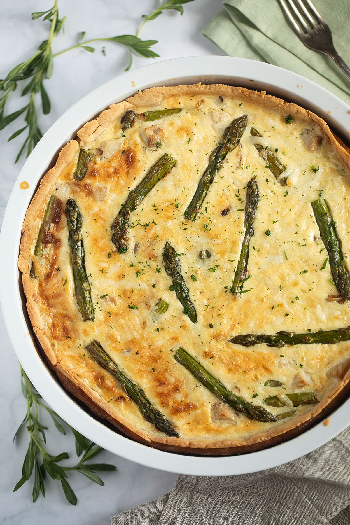 one large asparagus quiche with salmon in the baking dish.