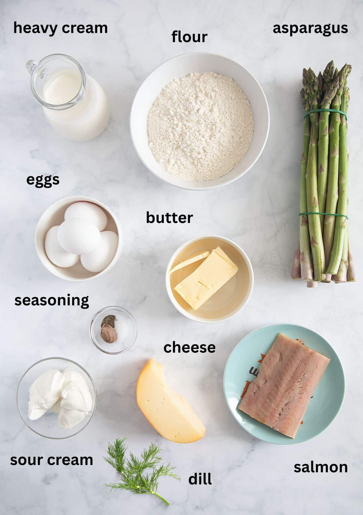 labeled ingredients for making quiche with salmon, asparagus, cheese, cream, flour and butter.