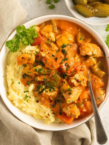 chicken goulash served with mashed potatoes in a bowl.