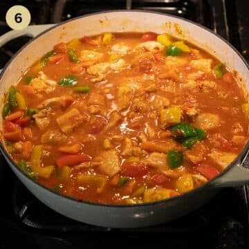 cooking goulash with chicken and peppers in a pan.