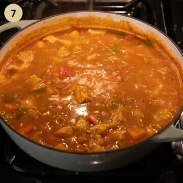 simmering chicken stew with peppers in a dutch oven.