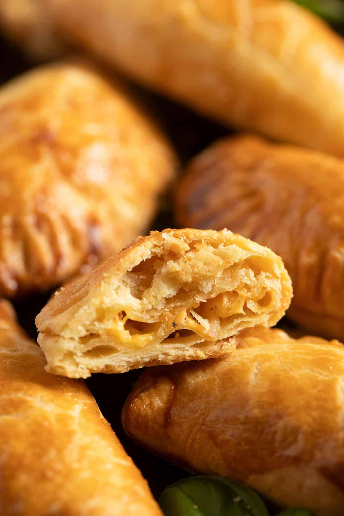 empanadas, one of them cut to show the cheesy filliing.