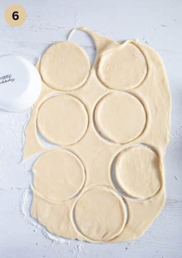 cutting disc out of rolled piece of dough to make empanadas.