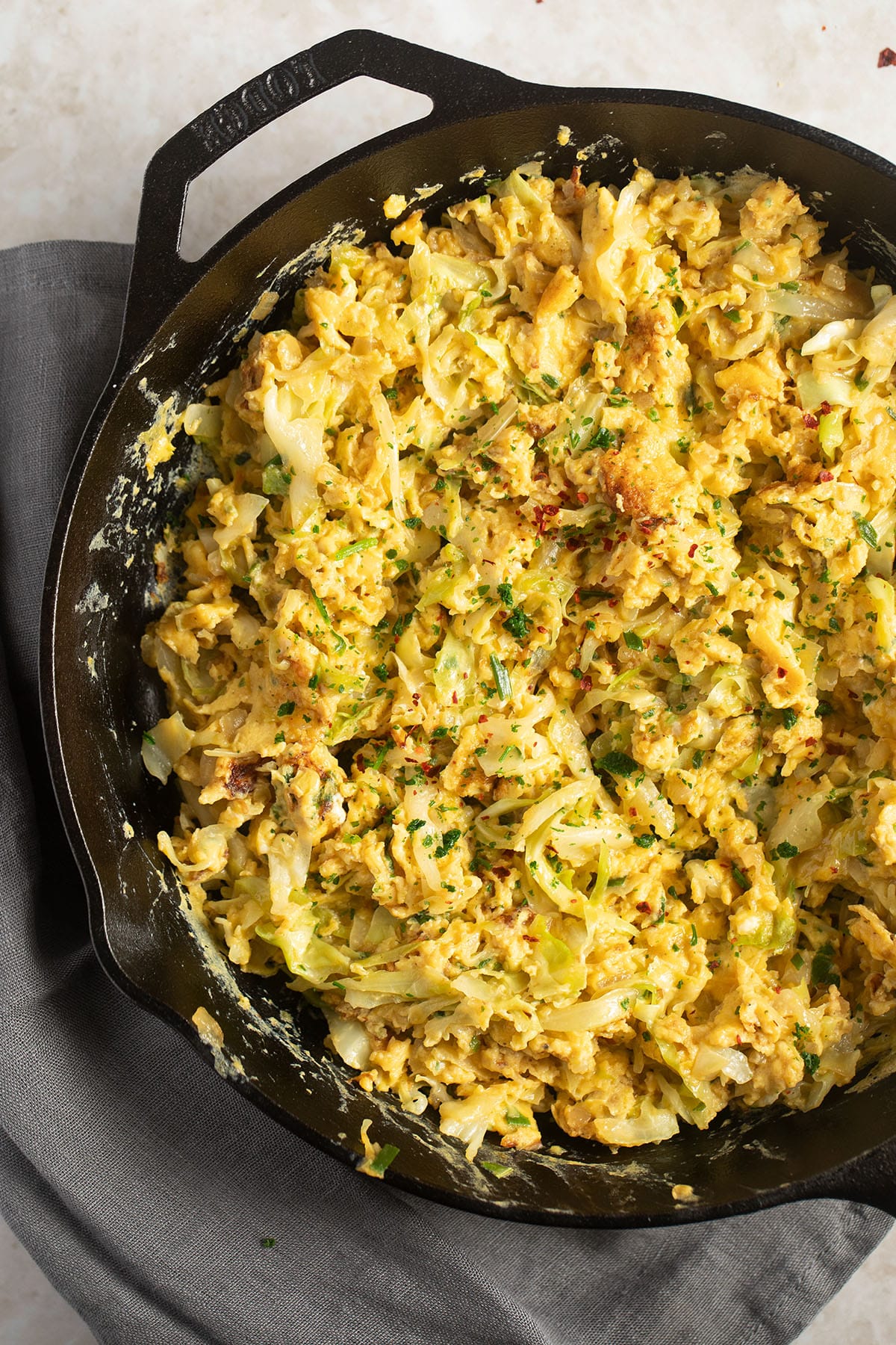eggs and cabbage in a cast iron skillet on the table.