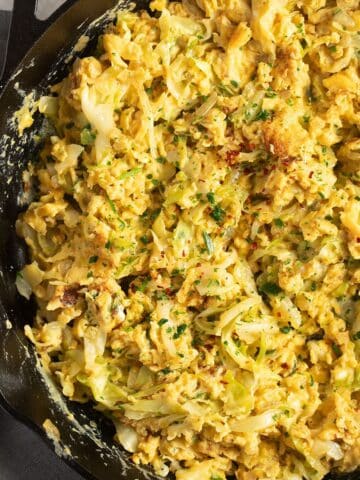 scrambled eggs and cabbage in a skillet.