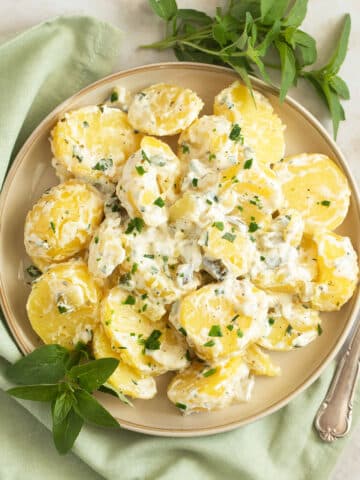 sour cream potatoes garnished with herbs on a plate.