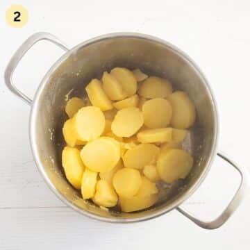 cooked, thick potato slices in a cooking pot.