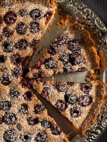 cherry tart with ground almond filling and sweet cherries on a vintage platter.