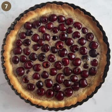 assembled cherry tart with ground almond filling before baking.