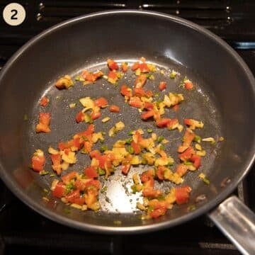 frying green chilies, onions, and tomatoes in a skillet to make omelet.