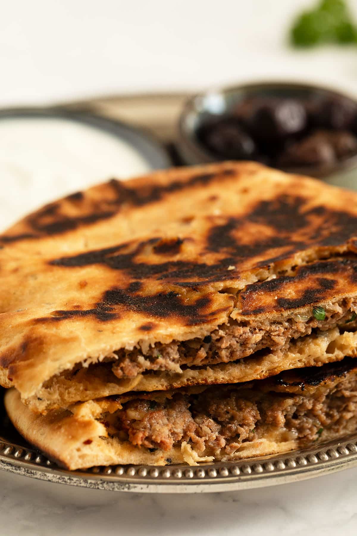 two lamb-stuffed pita bread cut to show the filling.