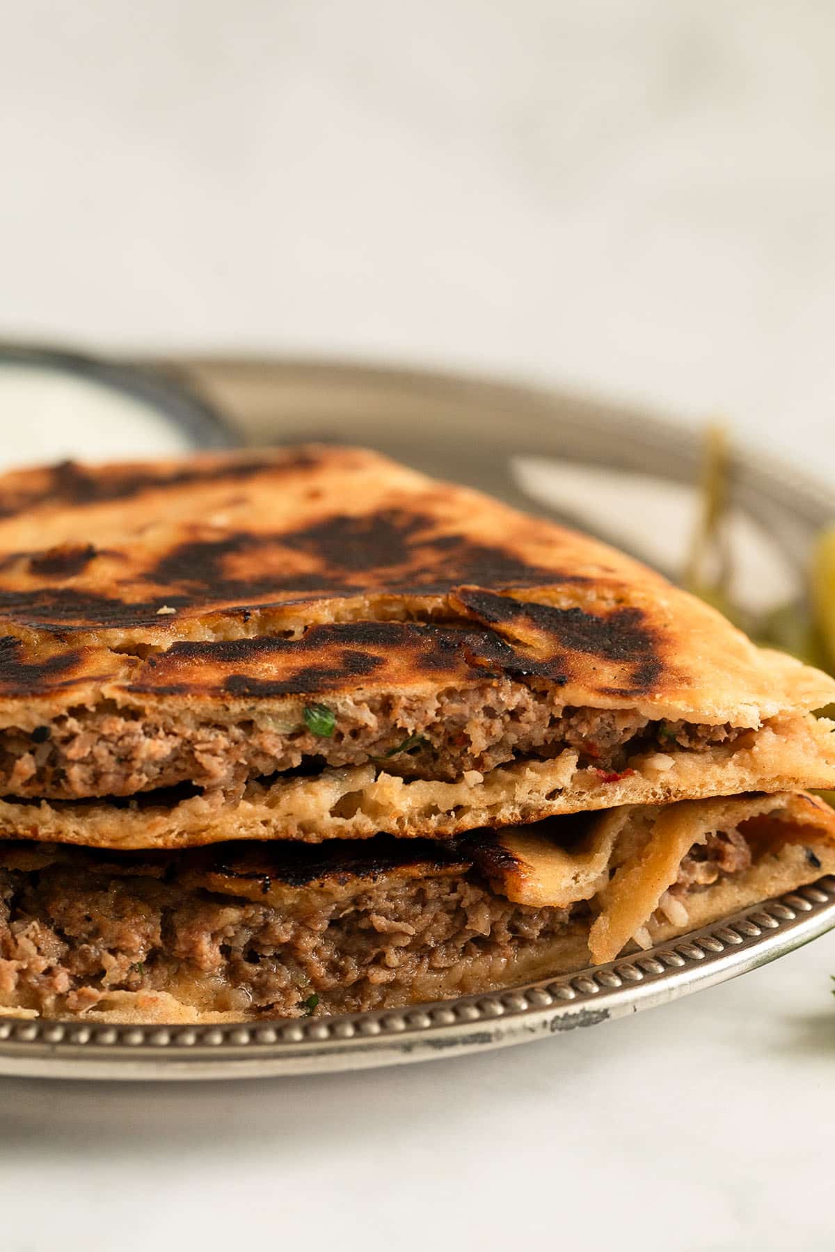 two arayes stuffed with lamb on a metal plate.