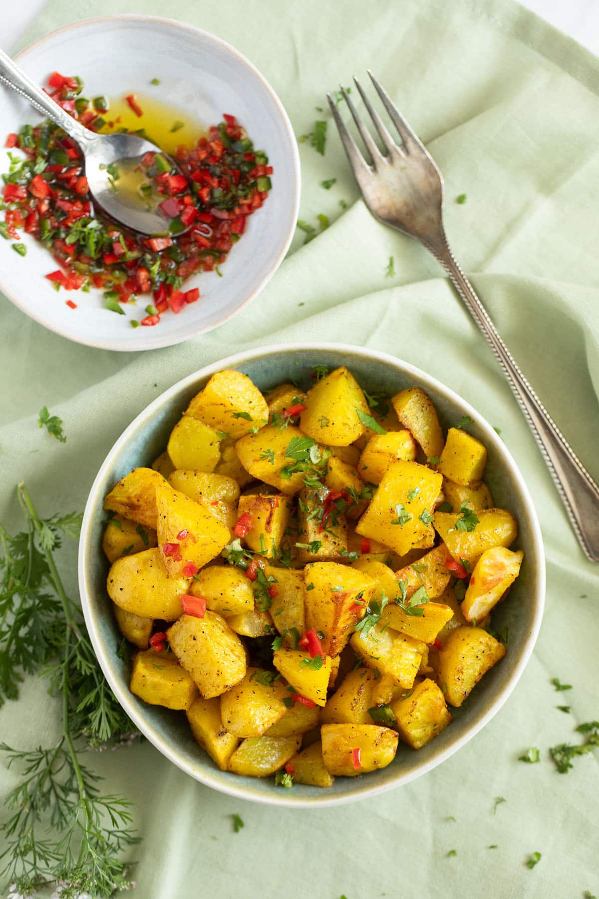 a bowl with lebanese potatoes and one with fresh chili sauce.