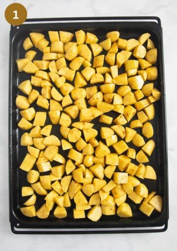 uncooked potato cubes on a baking sheet.
