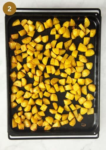 roasted potato cubes on a baking sheet.