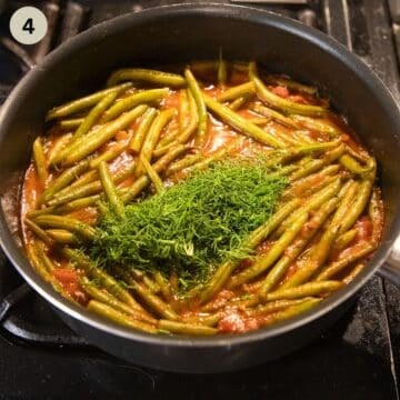 adding a lot of chopped fresh dill to a pot of stewing green beans.
