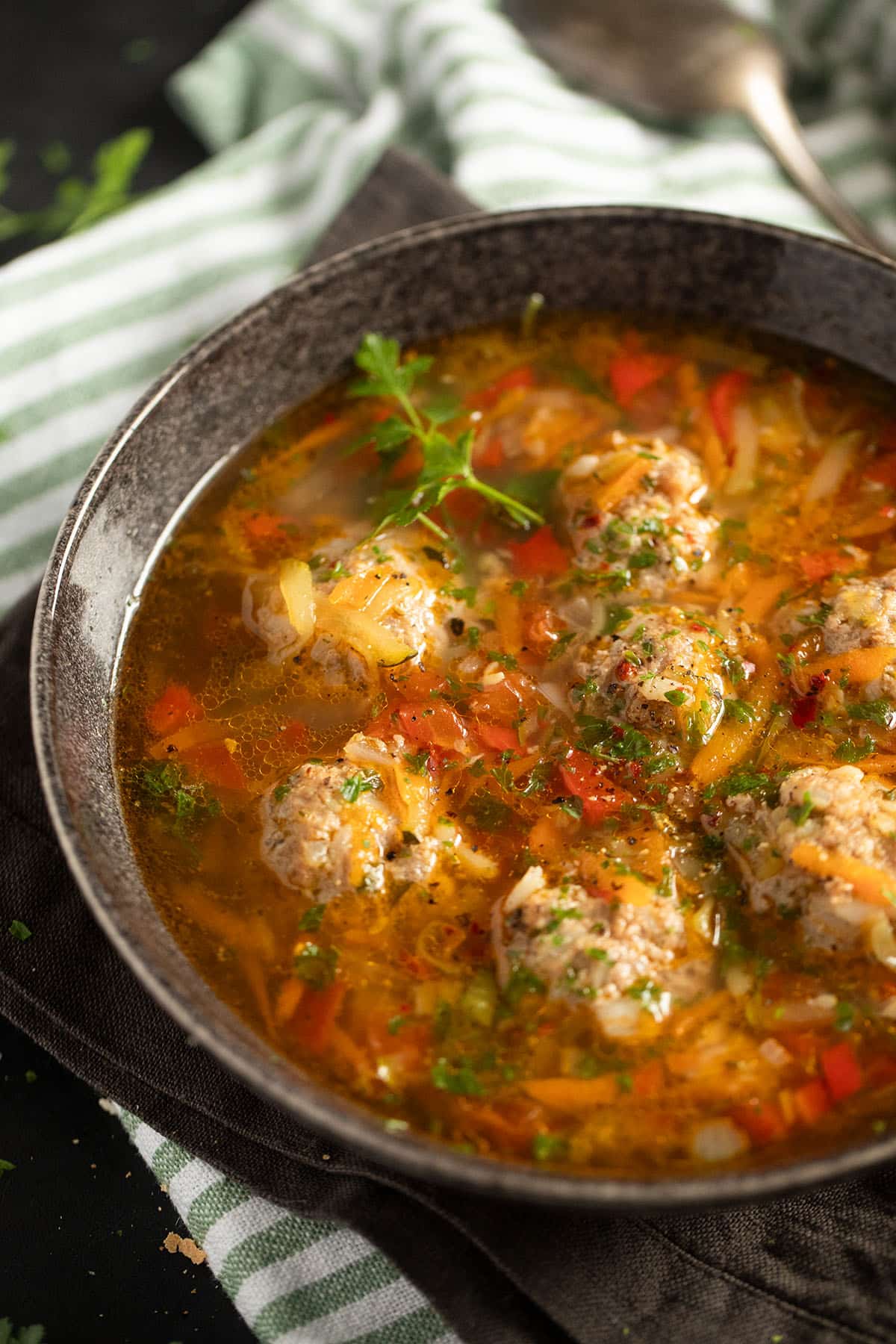a bowl of soup with large pork meatballs and veggies in a bowl.