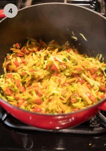 sauteing grated zucchini, carrots, onions and bell peppers for making soup.