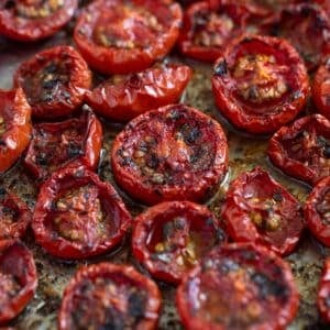 slow-roasted tomatoes collapsed and charred on a baking dish.