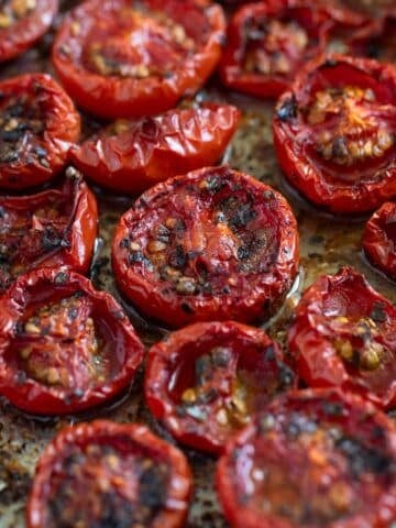 slow-roasted tomatoes collapsed and charred on a baking dish.