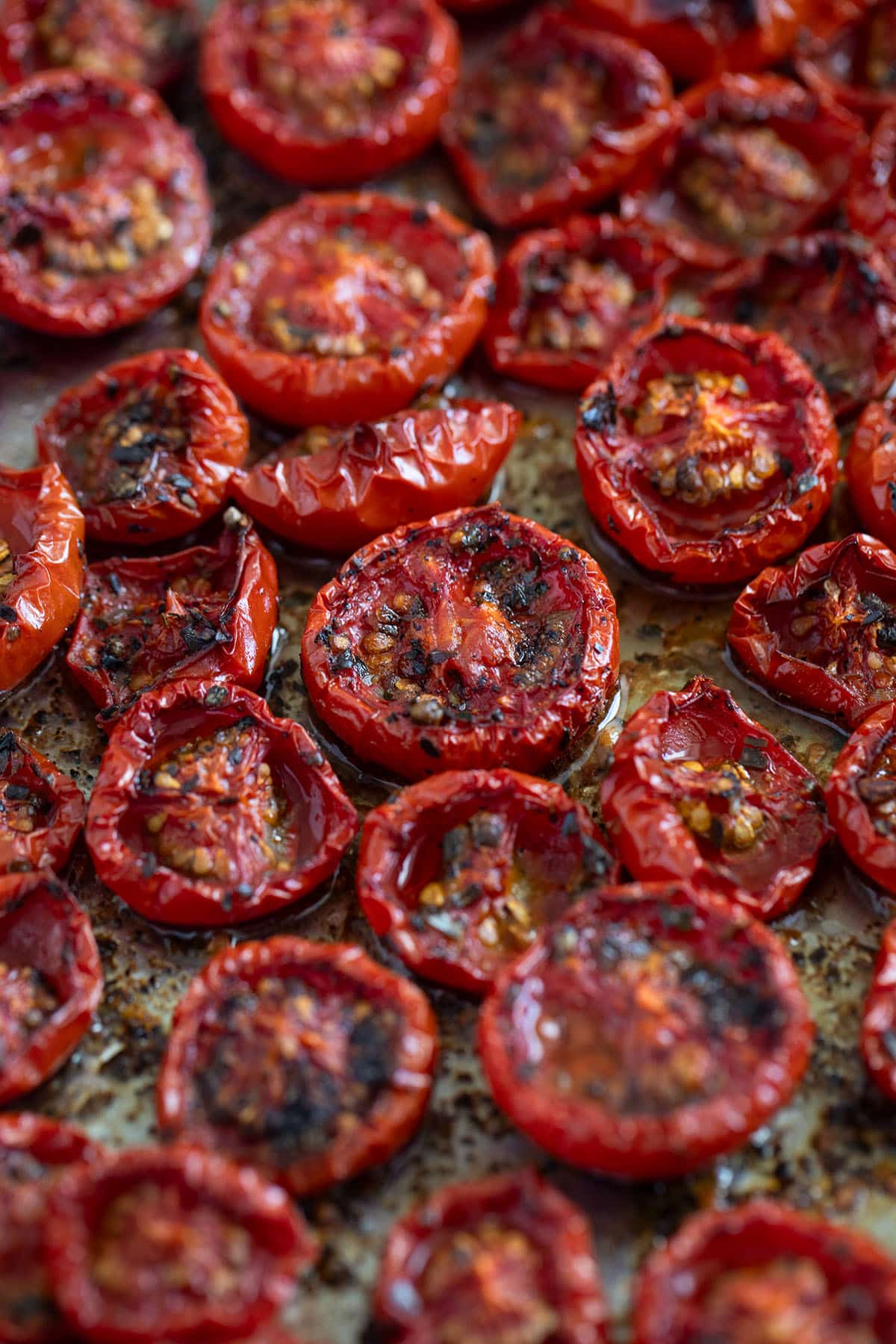 slow cooked tomatoes, charred and caramelized on a baking sheet.