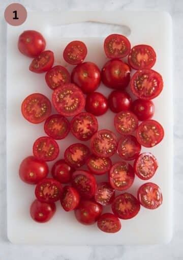 small, halved tomatoes on a cutting board.