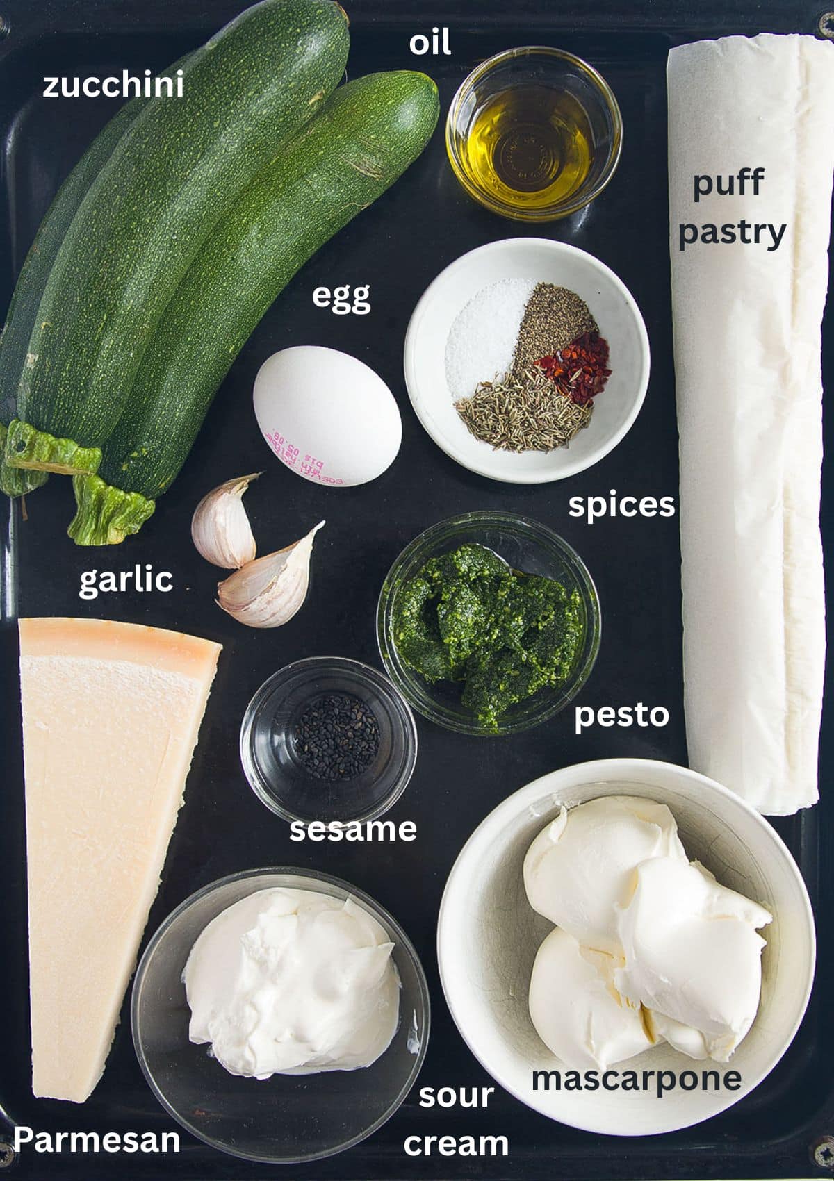 labeled ingredients for making zucchini tart with puff pastry, mascarpone, sour cream and parmesan.
