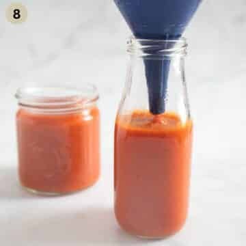 transferring ketchup to a bottle using a funnel.